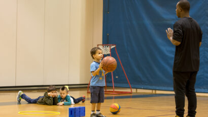Young boy practicing shooting a basketball.