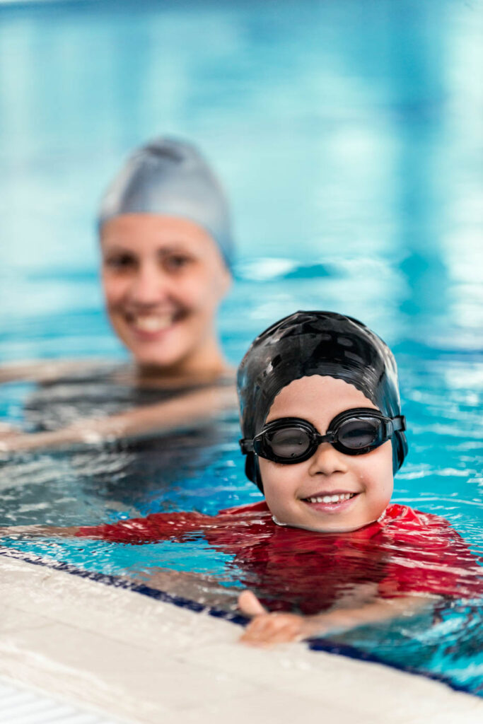 Instructor and student smiling in the pool.