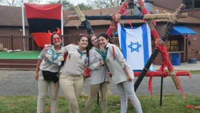 Girls standing next to an Israeli flag.