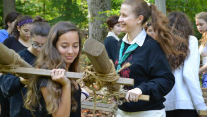 Girls carrying a wooden frame.