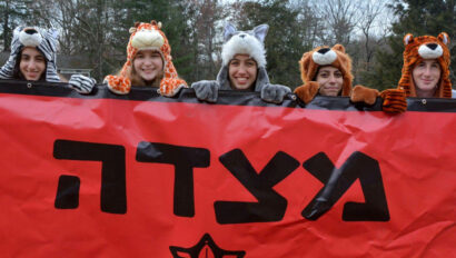 Girls holding up a red sign in Hebrew.