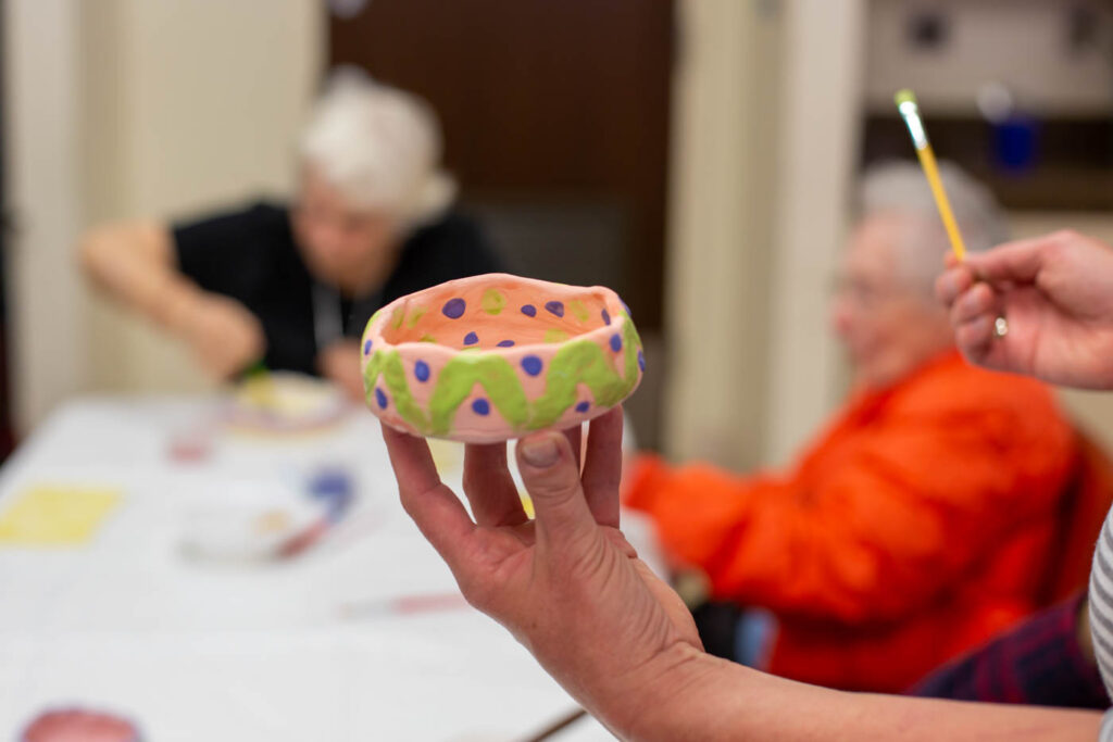 Seniors painting pottery.