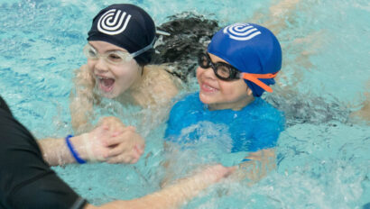 Two children taking swimming lessons.
