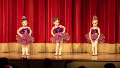 Young girls doing a ballet performance on stage.